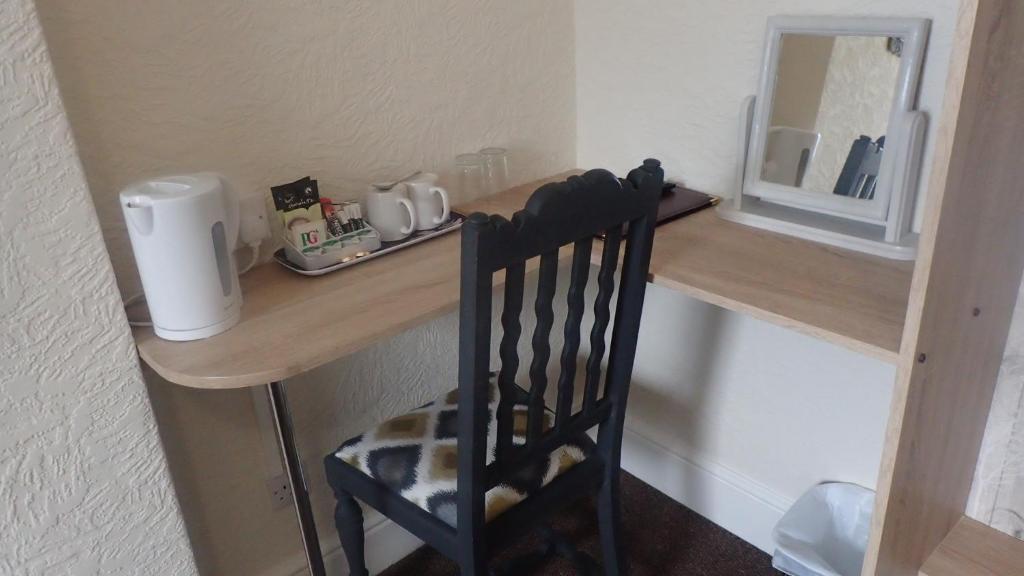a wooden desk with a chair in a room at The Victoria guest house in Mablethorpe