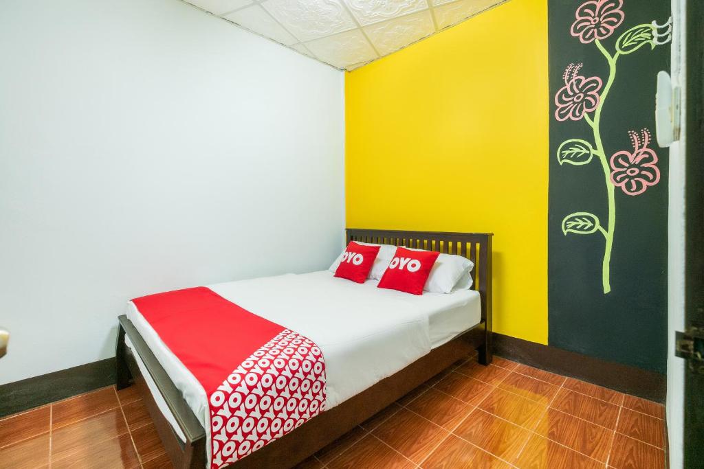 Un dormitorio con una cama con almohadas rojas. en OYO 608 Maleena Home, en Krabi