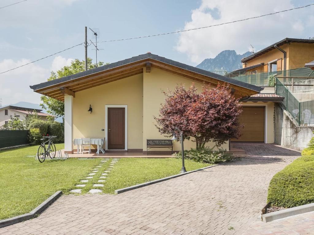 a small yellow house with a grass yard at Appartamenti Isola Verde in Villa