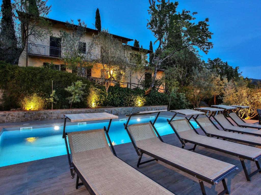 - un groupe de chaises assises à côté de la piscine dans l'établissement Belvilla by OYO Villa il Castello, à Castiglion Fiorentino
