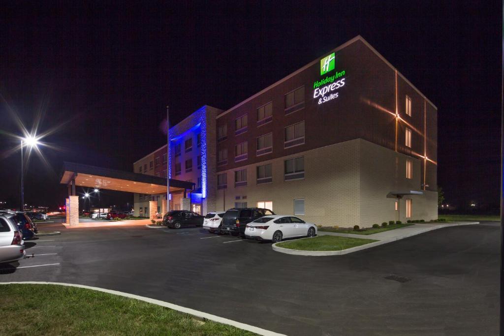 un hotel con coches estacionados en un estacionamiento por la noche en Holiday Inn Express & Suites - Indianapolis NW - Zionsville, an IHG Hotel en Whitestown