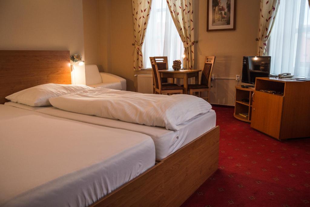 A bed or beds in a room at Hotel Roháč