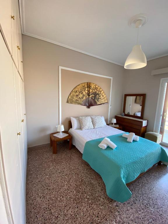 a bedroom with a large bed with a blue blanket at Mpanos Sea Apartment 2 in Loutra Oraias Elenis