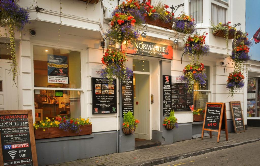 a restaurant with flowers on the side of a building at The Normandie in Tenby