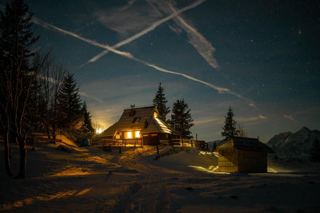 uma cabana de madeira na neve à noite em Chalet Tisa Velika Planina em Stahovica