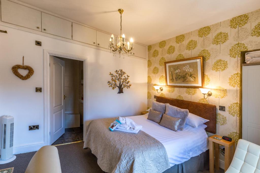 a bedroom with a bed and a chandelier at Forest Guest House in South Shields