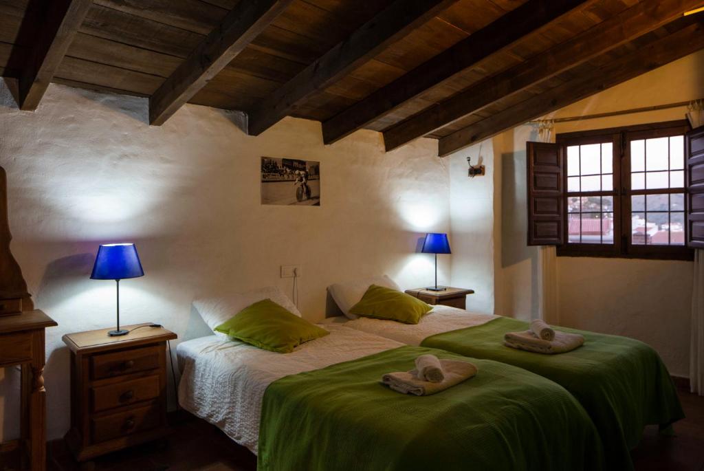 Un dormitorio con una cama con dos sombreros. en Casa de Luz, en Almáchar