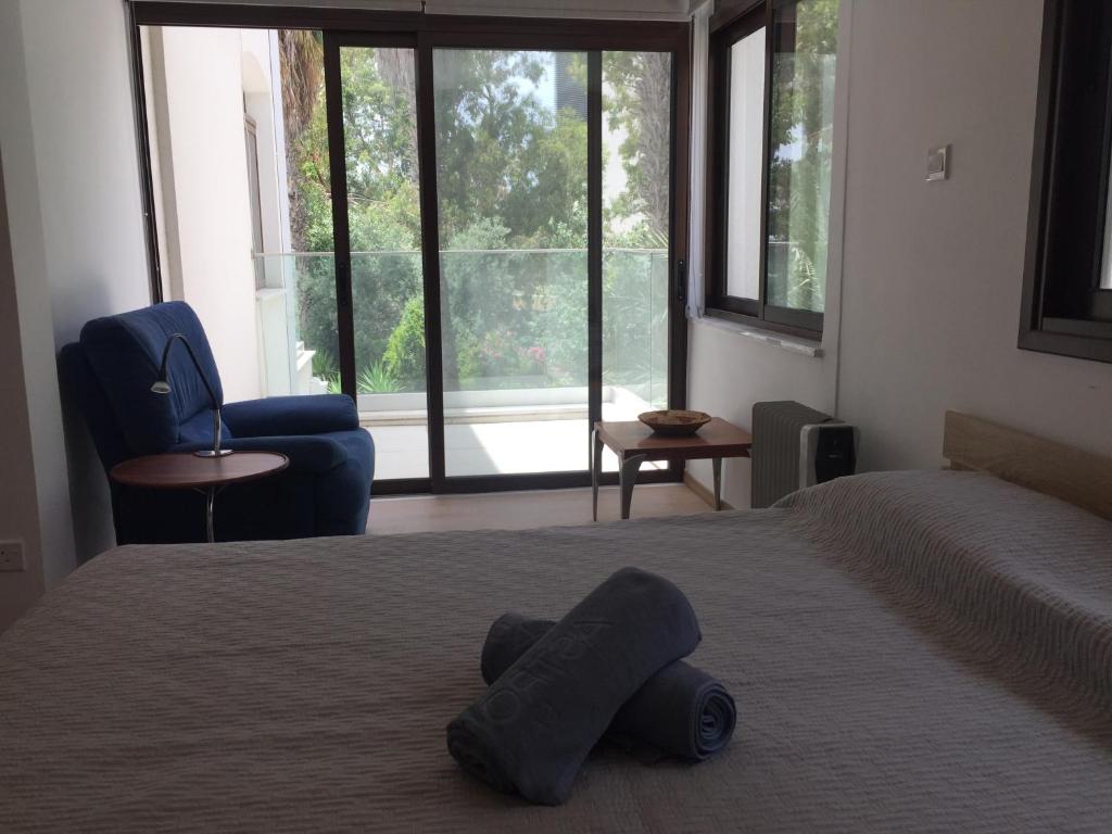 een slaapkamer met een bed en een groot raam bij Modern 2 bedroom Beach Apartment in Limassol