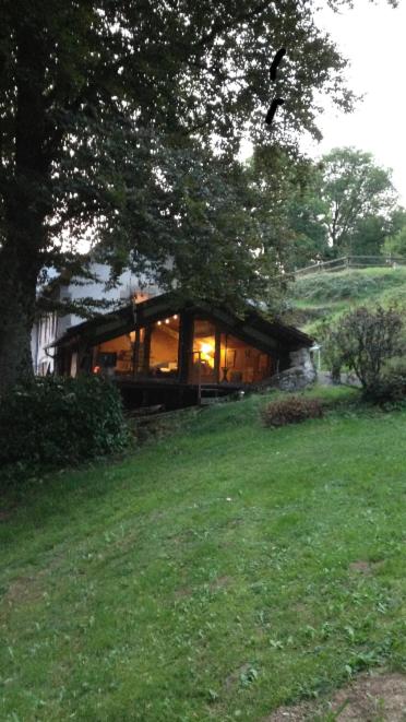 une maison avec beaucoup de fenêtres dans un champ dans l'établissement haras de la Cère et ses chevaux, à Polminhac