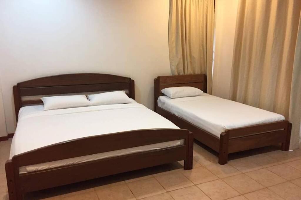 twee bedden in een hotelkamer met rokken bij Bonsai Villa @ Mesilou 盆栽小苑 in Kampong Kundassan