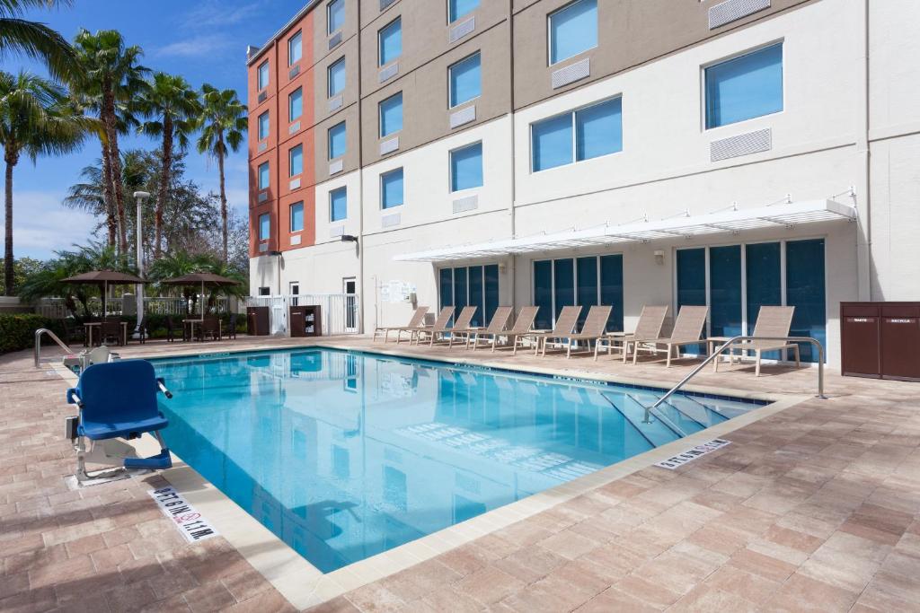 a swimming pool in front of a building at Holiday Inn Express Hotel & Suites Fort Lauderdale Airport/Cruise Port, an IHG Hotel in Fort Lauderdale