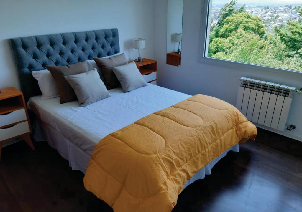 een slaapkamer met een groot bed en een groot raam bij Departamento en el centro de Bariloche ca in Bariloche