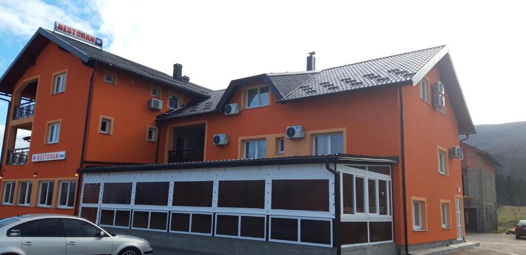 un edificio con un coche aparcado delante de él en Guest House Šapina, en Korenica