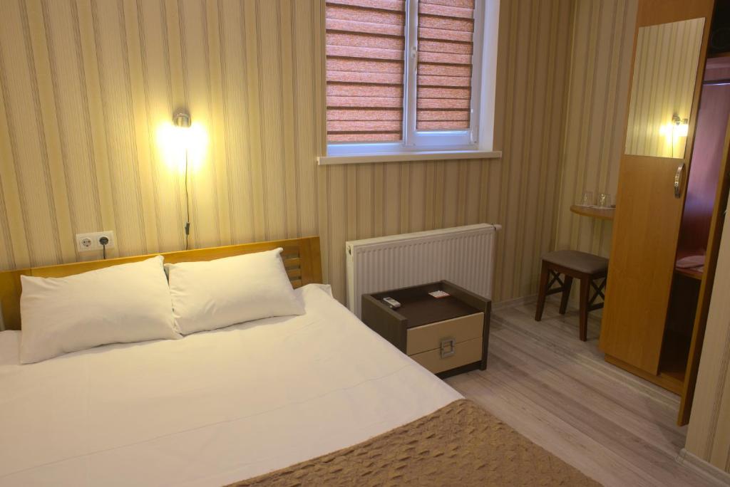 Schlafzimmer mit einem Bett, einem Tisch und einem Fenster in der Unterkunft The apartments in Kiew