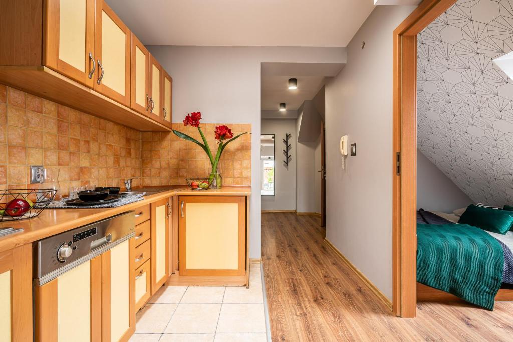 a kitchen with wooden cabinets and a bed in a room at Absynt Hostel Wrocław in Wrocław