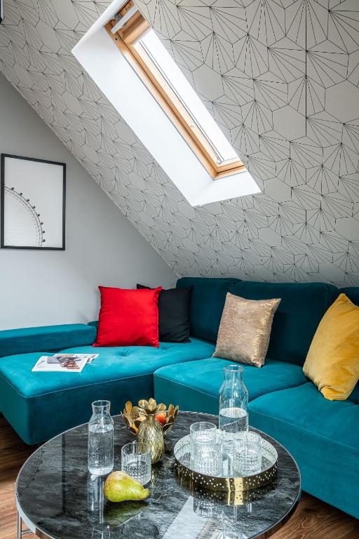 a living room with a blue couch and a table at Absynt Hostel Wrocław in Wrocław