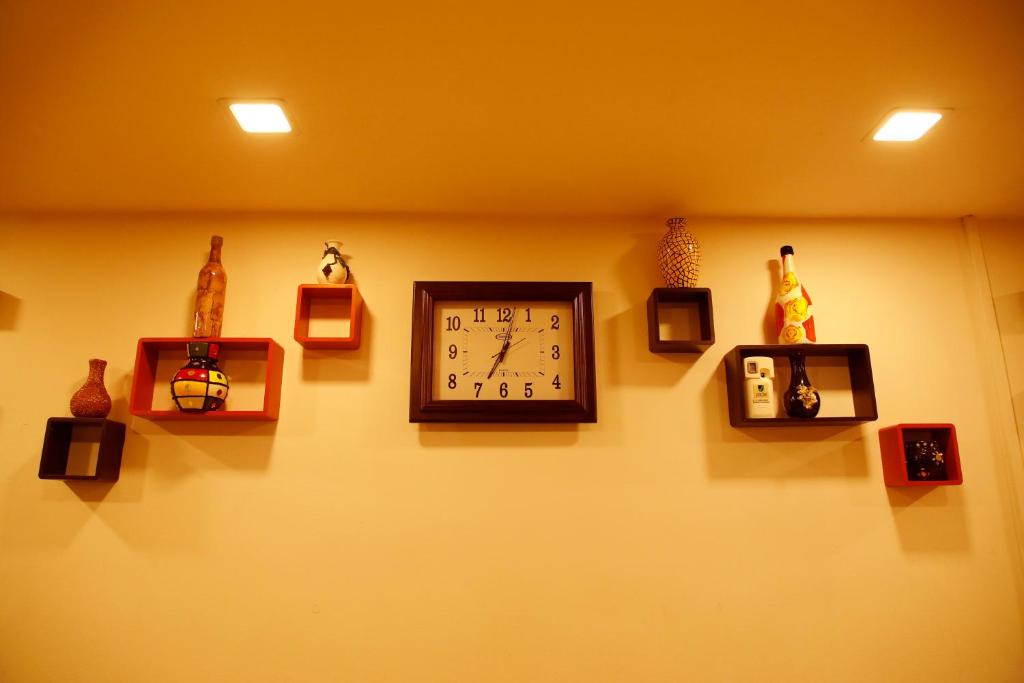 a wall with a clock on a wall at Kairali Tourist Home in Guruvāyūr