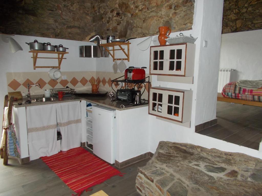 - une cuisine dans une maison de poupées avec un comptoir dans l'établissement Casas de Campo de Vale de Junco, à Envendos