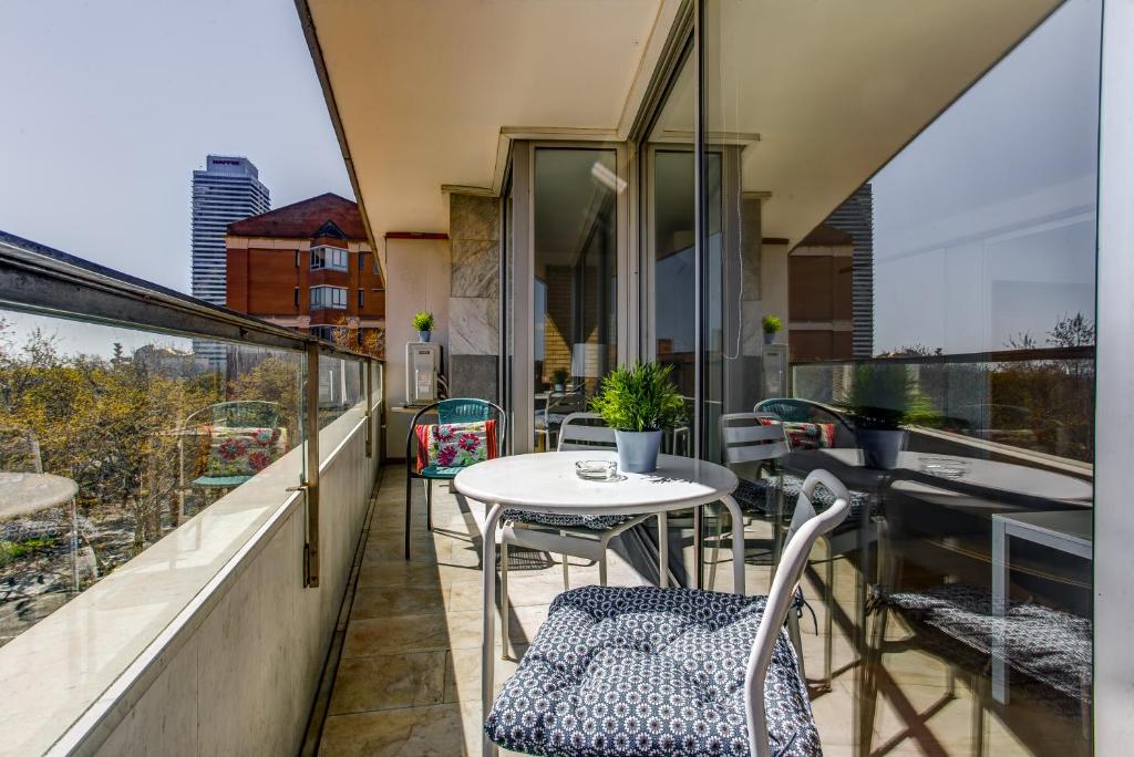 un balcón con mesa y sillas. en Lodging Apartments Beach Apartment Villa Olimpica, en Barcelona