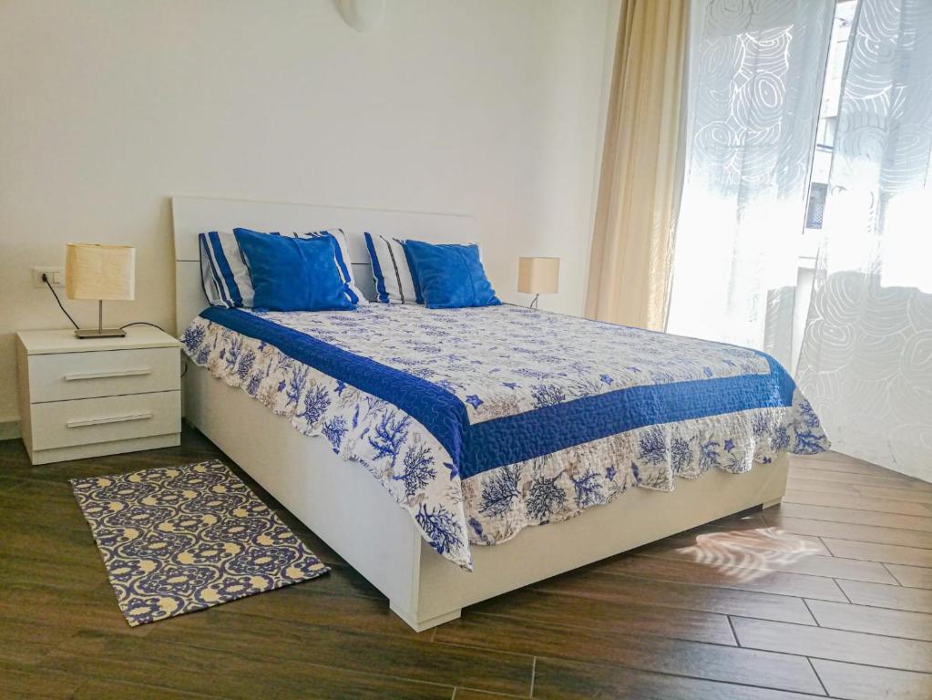 um quarto com uma cama com almofadas azuis e uma janela em Appartamento Azzurro Mare em Sestri Levante