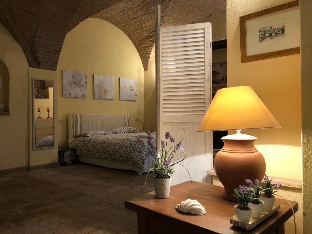 ein Schlafzimmer mit einem Bett und einem Tisch mit einer Lampe in der Unterkunft Da Patou in Todi