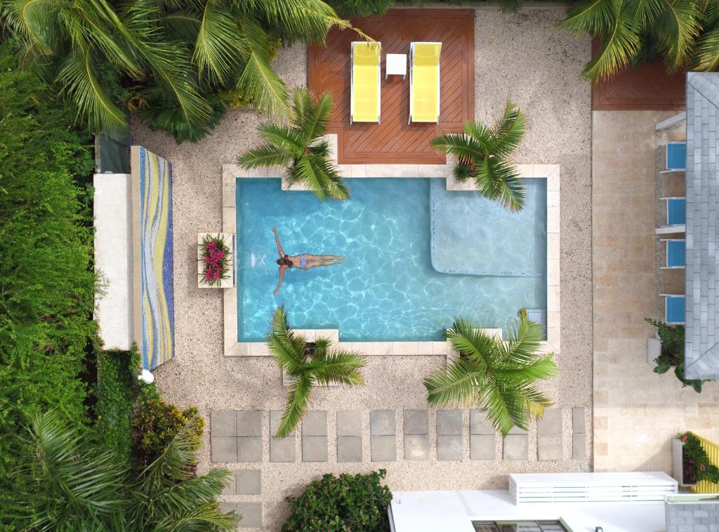 una vista aérea de una piscina con un hombre nadando en Bubali Bliss Studios, en Palm-Eagle Beach