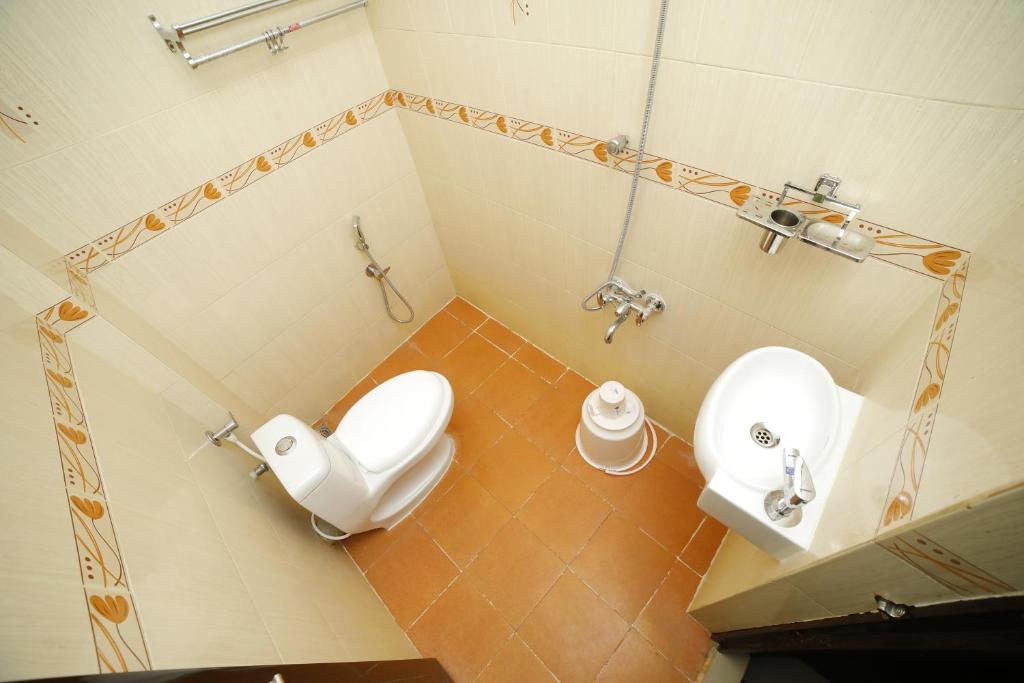 a bathroom with a toilet and a sink at Kairali Tourist Home in Guruvāyūr