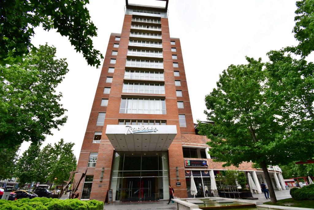 a tall red brick building with a tower at Radisson Ciudad Empresarial Santiago in Santiago