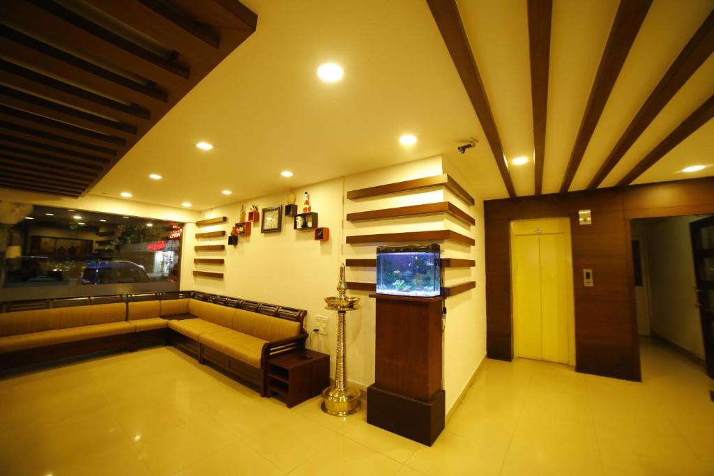 a living room with a couch and a television at Kairali Tourist Home in Guruvāyūr