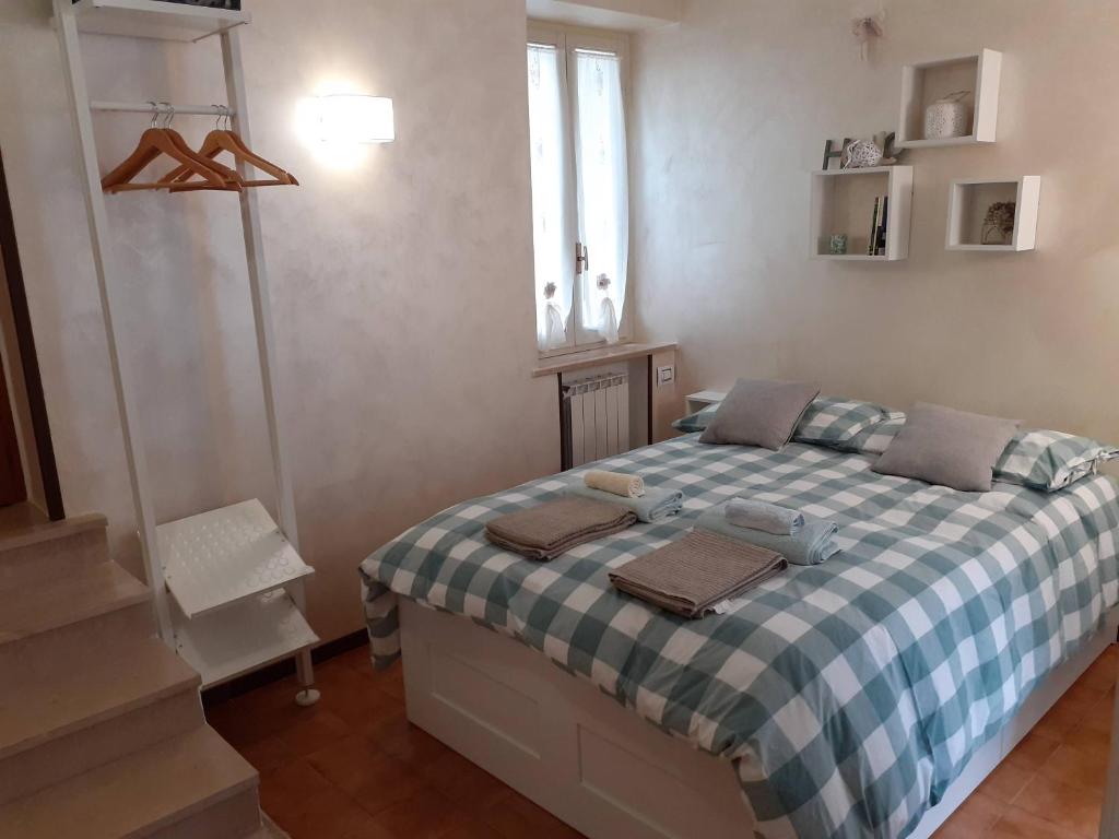 Un dormitorio con una cama con una manta de cuadros azul y blanco en Casa di Via Nuova, en Spoleto