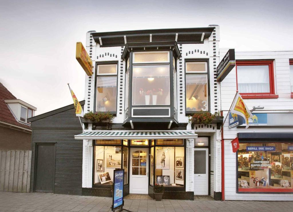 una tienda frente a un edificio blanco con ventanas en Bbstudio3 en Den Helder