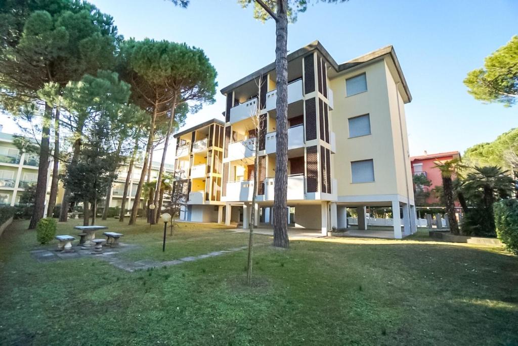 un edificio de apartamentos con un parque enfrente en Residence Goletta, en Bibione