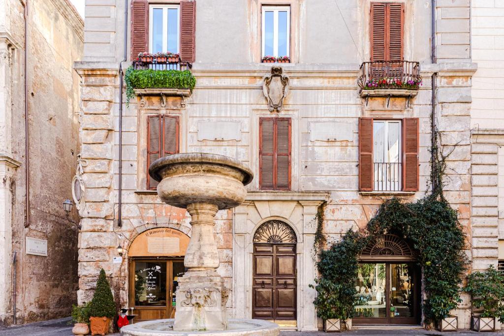 a building with a fountain in front of a building at Coronari Suite in Rome