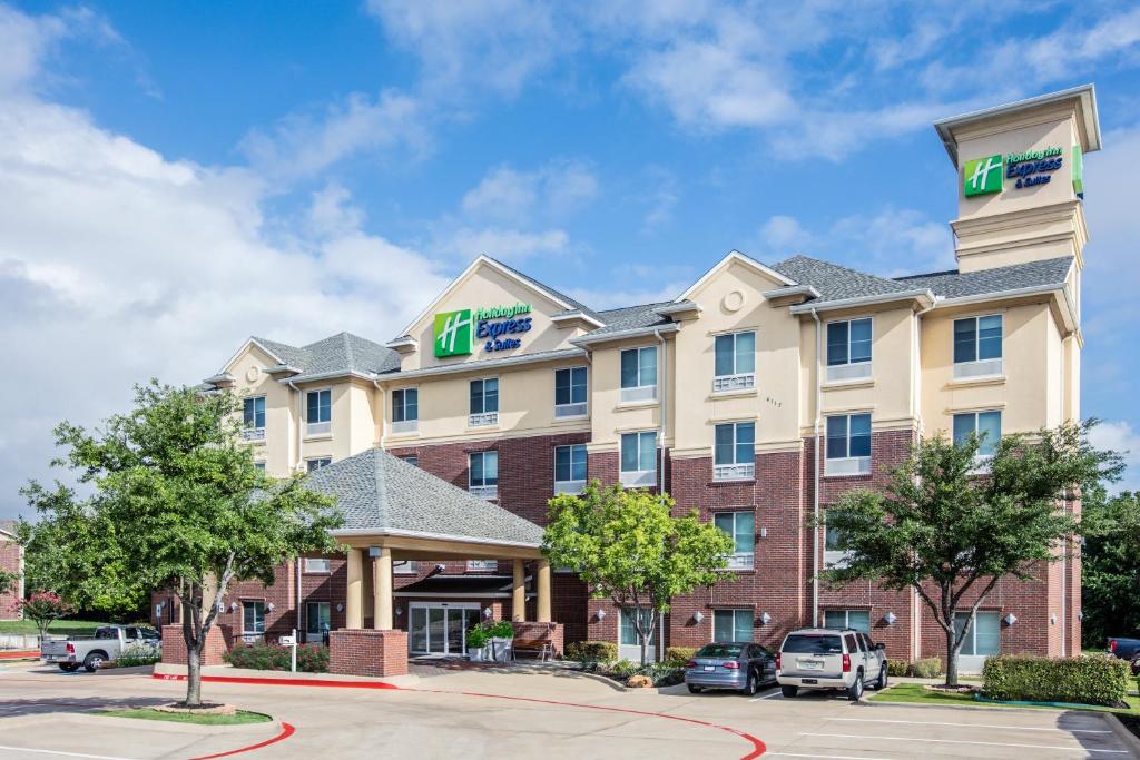 uma imagem de um hotel com carros estacionados num parque de estacionamento em Holiday Inn Express Hotel & Suites Dallas - Grand Prairie I-20, an IHG Hotel em Grand Prairie