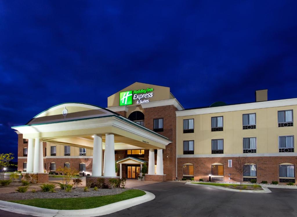 um exterior de hotel à noite com um hotel iluminado em Holiday Inn Express Hotel & Suites Bay City, an IHG Hotel em Bay City