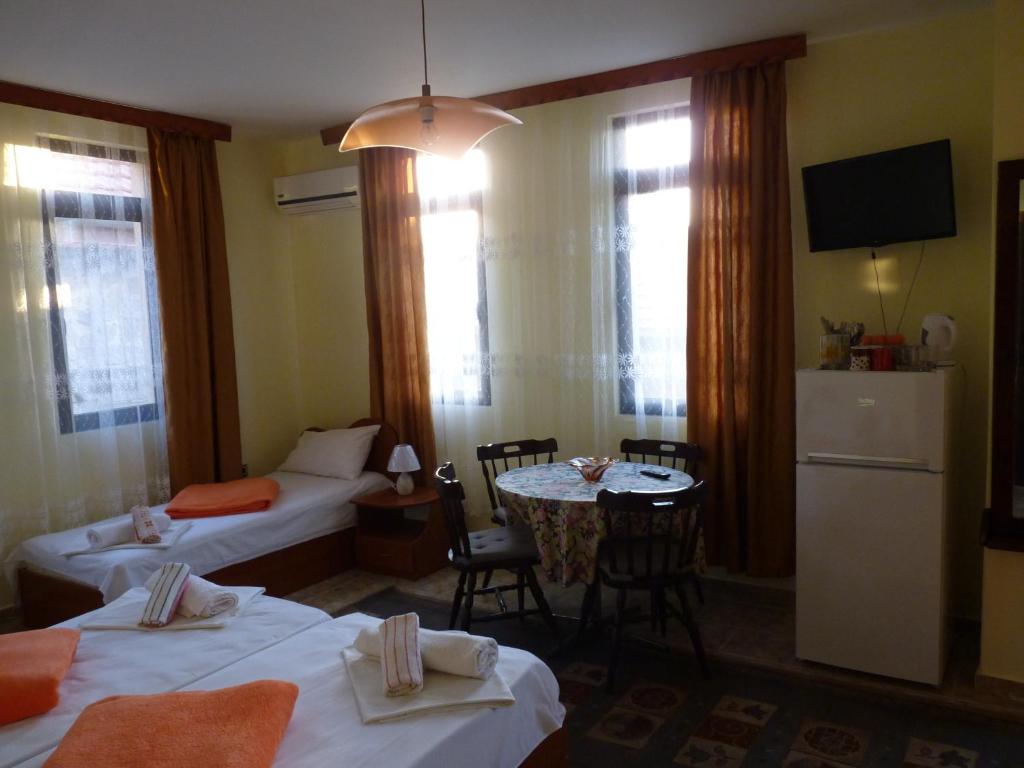ソゾポルにあるGuest House Zheleviのベッド2台とテーブルが備わるホテルルームです。