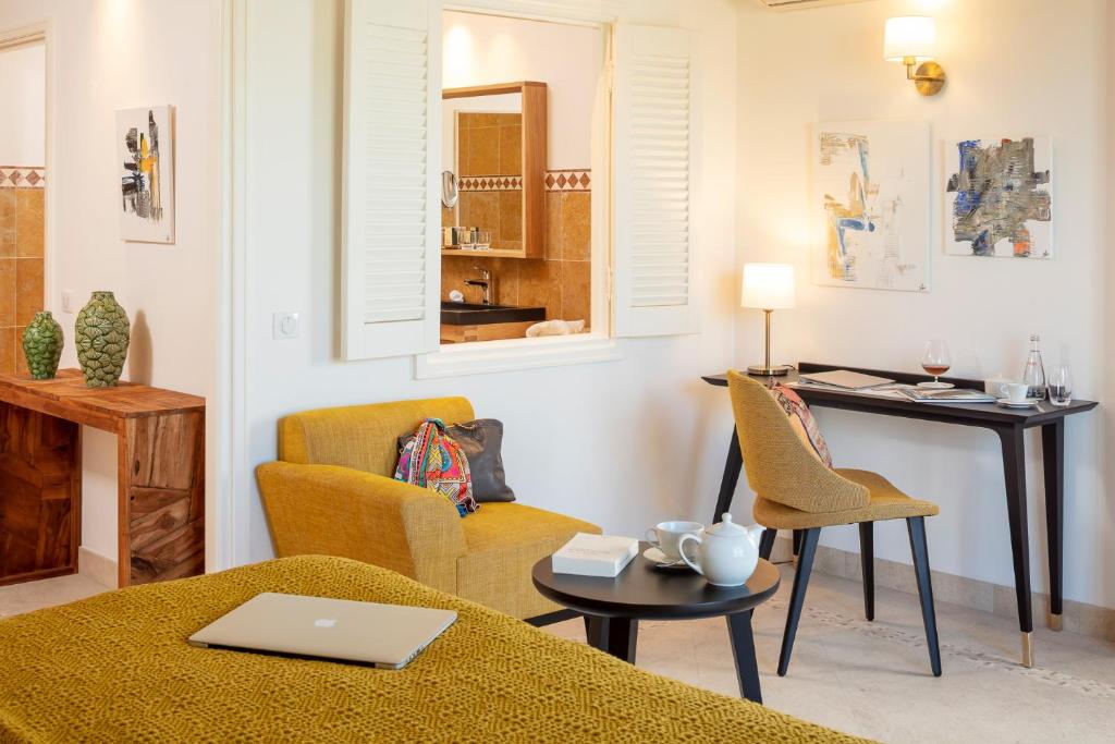 a living room with a table and chairs and a desk at Domaine de l'Astragale in Saint-Tropez