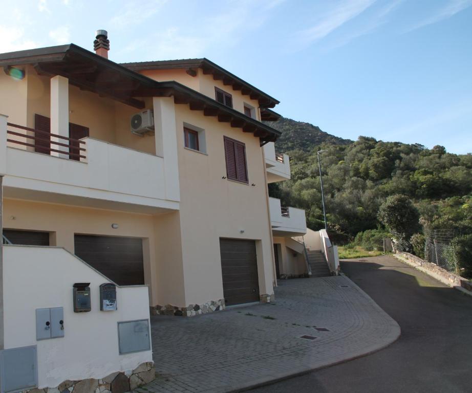 una casa con dos puertas de garaje y una montaña en Appartamenti Amaretto e Pardula, en Fluminimaggiore