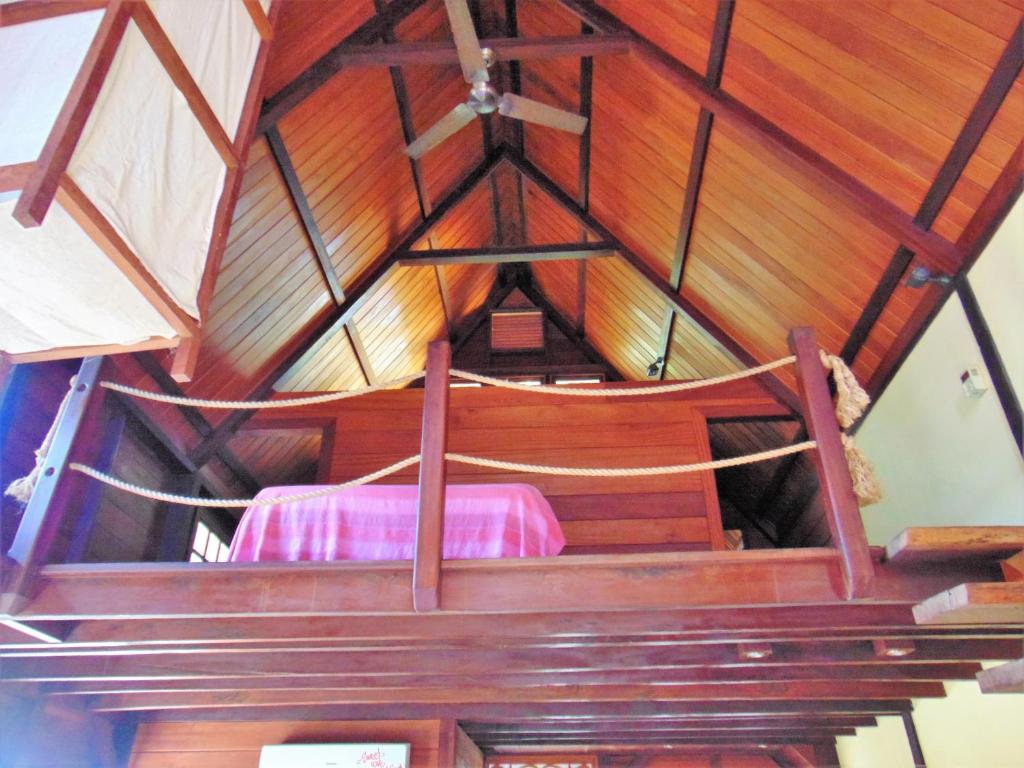 Zimmer mit einem Bett in einer Holzdecke in der Unterkunft Yellow Houses Bocas DUPLEX in Bocas del Toro