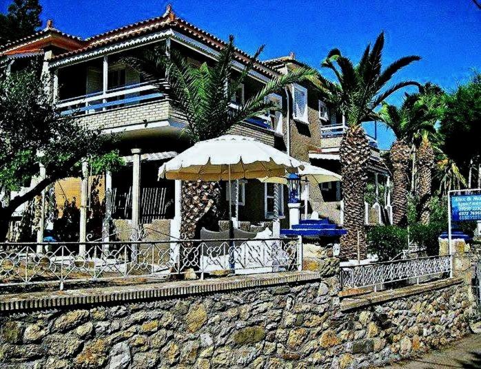a house with two umbrellas in front of it at Alex - Nancy Apartments - Zaga Beach in Koroni