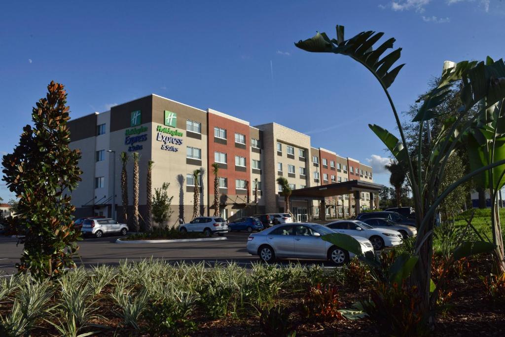 a parking lot with cars parked in front of a building at Holiday Inn Express & Suites - Orlando - Southeast, an IHG Hotel in Orlando