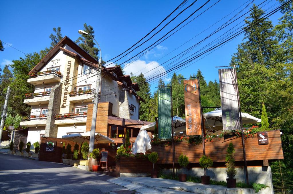 a hotel with a building on the side of the street at Hotel Piatra Soimului in Sinaia