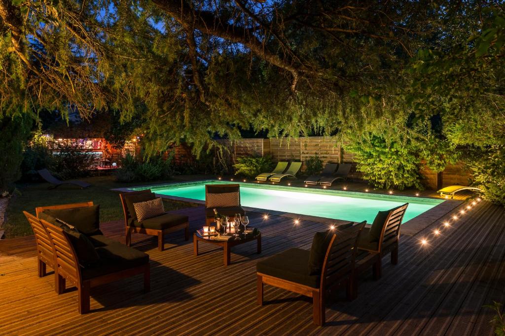 une cour avec une piscine, des chaises et une table dans l'établissement Hôtel Mas Vidau Porte des Alpilles, à Saint-Étienne-du-Grès