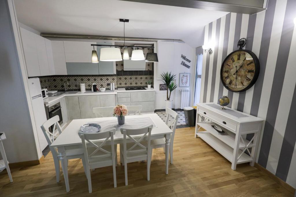 kuchnia ze stołem, krzesłami i zegarem w obiekcie HAPPY HOUSE 31 w mieście Neapol
