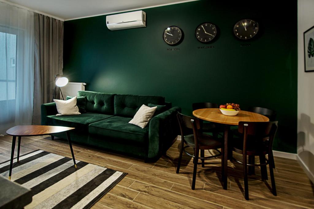 a living room with a green couch and a table at Apartament Centrum XL - Komfortowe Noclegi in Piaseczno