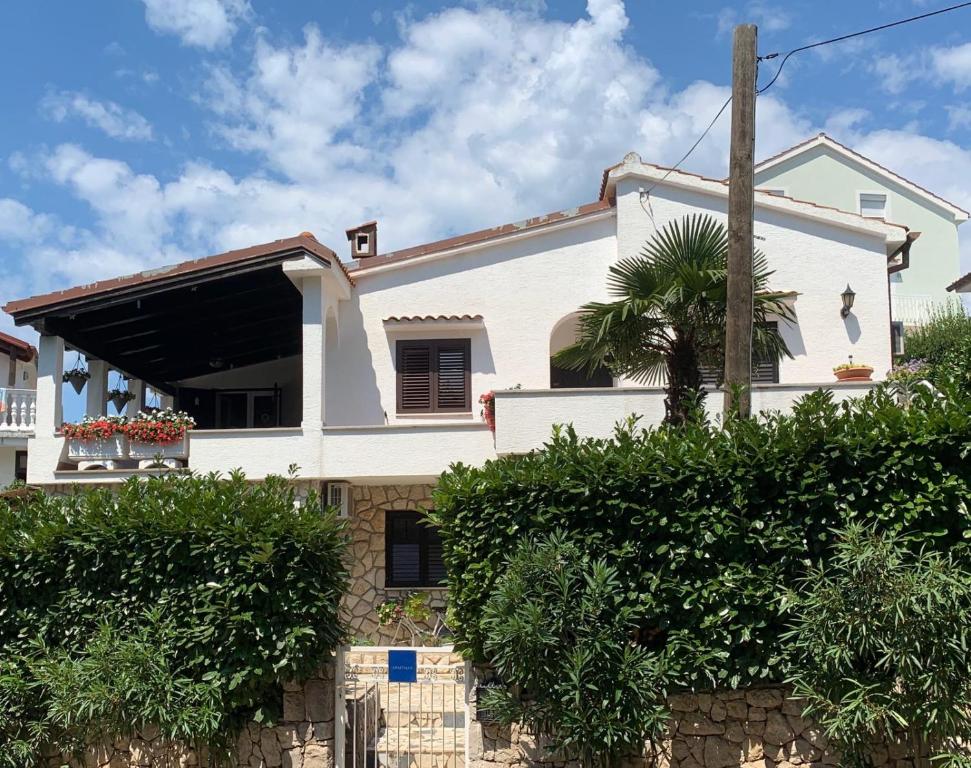 ein weißes Haus mit einer Palme davor in der Unterkunft Villa Gromaca in Omišalj