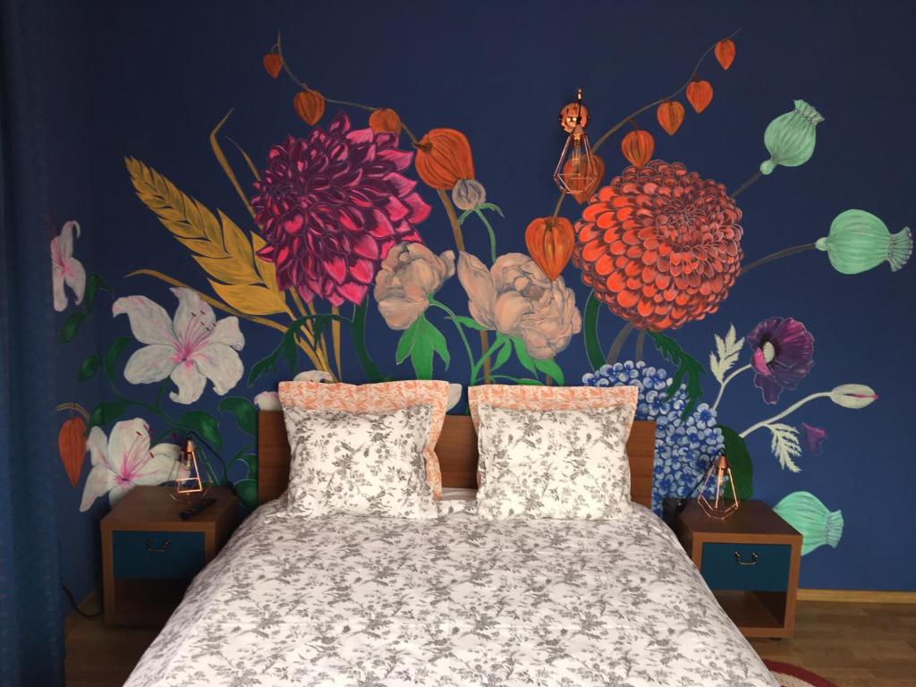 a bedroom with a flower mural on the wall at Pensiunea Victoria in Râşnov