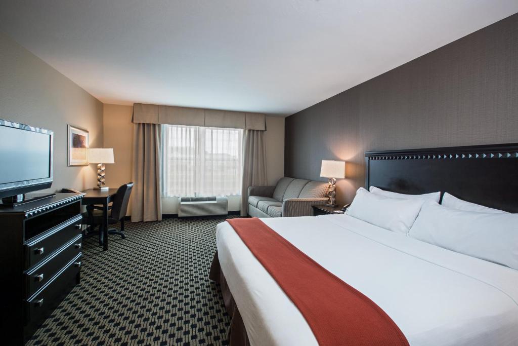 a hotel room with a bed and a flat screen tv at Holiday Inn Express & Suites - Green Bay East by IHG in Green Bay