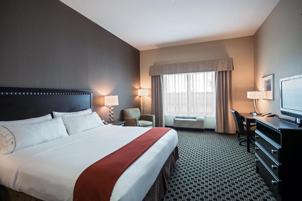 a hotel room with a large bed and a television at Holiday Inn Express & Suites - Green Bay East by IHG in Green Bay