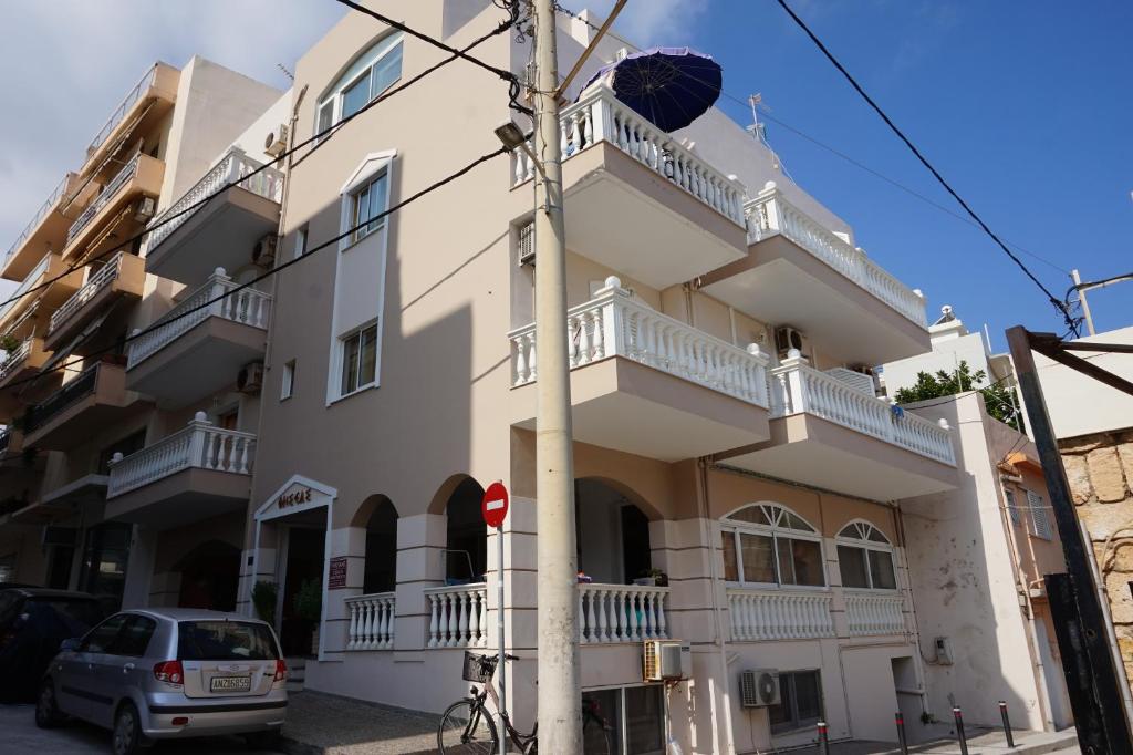 un edificio blanco con balcón en una calle en Thiseas Studios en Rethymno